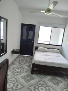 Puerto BerríoHOTEL DORADO PUERTO BERRIO的一间卧室设有一张床和两个窗户。