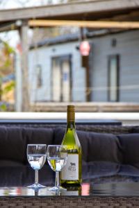 雷讷瑟Zee&Zout, chalet 6 pers. bij Renesse en strand!的桌子上放有一瓶葡萄酒和两杯酒