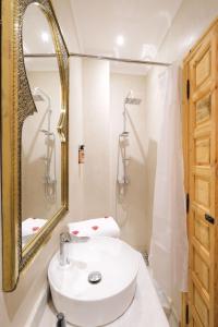 马拉喀什Riad El Habib的浴室设有白色水槽和镜子