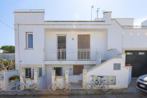 莱乌卡Leuca Mon Amour的三辆自行车停在白色房子前面