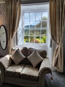 安布尔塞德Foxghyll Country House的客厅设有一张沙发,配有大窗户