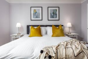 普雷斯蒂克Shore View - Donnini Apartments的一间卧室配有一张带黄色枕头的大床