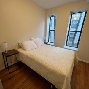纽约Harlem House的配有2扇窗户的客房内的1张床