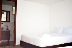 帕斯托Hotel Villa Isabel的卧室配有白色的床和镜子