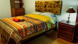 瓦拉斯Kame House hostel的一间卧室配有一张带木制床头板的床