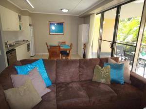 彩虹海滩Baden 90 Rainbow Shores的客厅里配有带枕头的棕色沙发
