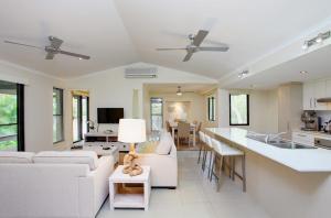 彩虹海滩6 Orania Court Rainbow Shores的一间带白色家具的客厅和厨房
