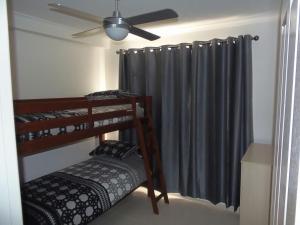 彩虹海滩Palmgrove 2 Rainbow Beach的一间卧室设有两张双层床和吊扇