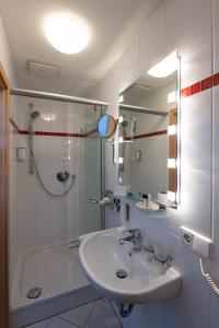 科尔恩塔尔-明欣根Landschloss Korntal的白色的浴室设有水槽和淋浴。