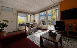 代讷坎普Fijne plek met eigen bos 2000m2 en GRATIS linnen en handdoeken!!的客厅配有红色的沙发和桌子