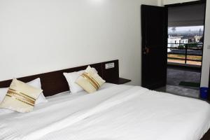 JhirnaCorbett Bhavesh home Stay的卧室配有一张大白色床和窗户