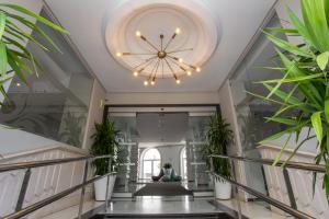 塞维利亚蒙泰特里亚纳酒店的走廊上种植了植物,天花板上设有吊灯