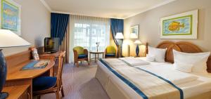 赛巴特班森班辛风情旅游度假酒店的酒店客房设有一张大床和一张书桌。