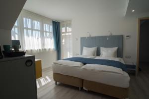 索普隆Hotel Civitas的一间卧室配有一张带蓝白色枕头的大床