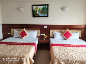 格卢市社Khách sạn NHẬT MINH Cửa Lò的两张睡床彼此相邻,位于一个房间里