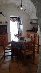 莫纳奇尔Casa Cueva Sierra Nevada - Monachil的厨房配有桌椅和窗户。