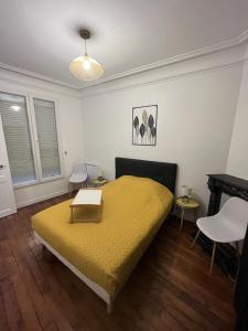 圣芒代Un appartement authentique à deux pas de Paris .的一间卧室配有一张黄色的床,上面有桌子