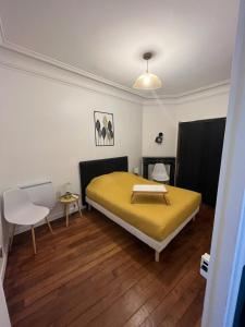圣芒代Un appartement authentique à deux pas de Paris .的一间卧室设有黄色的床,铺有木地板。