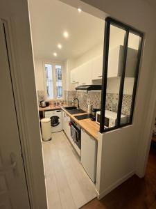 圣芒代Un appartement authentique à deux pas de Paris .的厨房配有白色橱柜和炉灶烤箱。