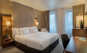 杜塞尔多夫杜塞尔多夫美利亚酒店的酒店客房设有一张大床和一张书桌。