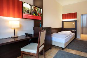 波恩ACHAT Sternhotel Bonn的酒店客房设有两张床、一张桌子和一台电视。
