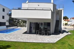 比奥格勒·纳·莫鲁Villa Dalija的白色的房子,设有庭院和游泳池