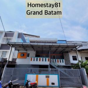 名古屋Homestay 81 Grand Batam的两辆摩托车停在楼前的建筑物