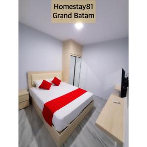 名古屋Homestay 81 Grand Batam的一间卧室配有一张带红色枕头的大床