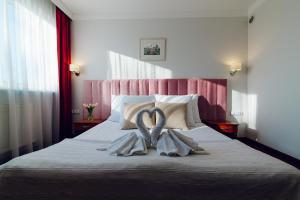 威赫罗伏维多利亚酒店的一间卧室配有一张床,上面有两条毛巾