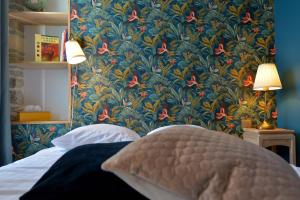 瑟堡Hôtel Le Tiburon的卧室配有蓝色和红色花卉壁纸