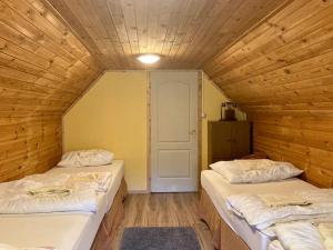 TiszaderzsHarcsáztat-Lak的木墙客房的两张床
