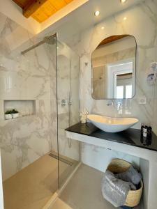 图罗斯Paradisia Villas的一间带水槽和玻璃淋浴的浴室