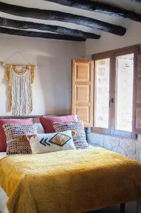 Torre del ComptePrecioso loft rural con estufa de leña panorámica的一间卧室配有一张黄色毯子床
