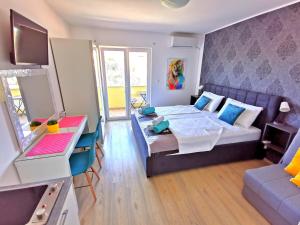 罗戈兹尼察Apartments CVITA HOLIDAY - Villa NATALI的一间卧室配有一张床、一张桌子和一张沙发