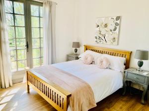 PomportLes Grands Bois的卧室配有一张带两个枕头的大白色床