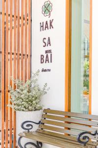 Ban Huai BongHaksabai Hotel Chiangrai โรงแรมฮักสบาย เชียงราย的木凳坐在一扇门前,种植植物
