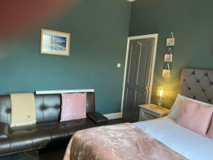 卡迪夫Inn Cardiff的一间卧室配有一张床和一张皮沙发