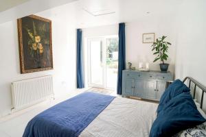 本布里奇Seashell, Bembridge的一间卧室设有蓝色的床和窗户。