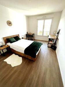 GagnyNeoresid Paris-Gagny的一间卧室设有一张大床,铺有木地板