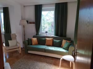 博尔扎诺TORRE GARDEN HOME - casa singola nella città di Bolzano con giardino privato的客厅设有绿色沙发和窗户。