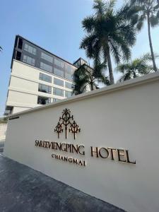 清迈Sareeviengping Hotel Chiangmai的棕榈树酒店前的标志