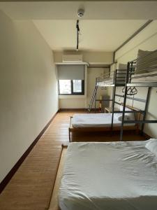 嘉义市Chiayi Petite Hostel的客房设有两张双层床和一扇窗户。