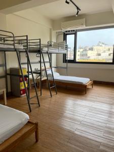嘉义市Chiayi Petite Hostel的客房设有三张双层床和大窗户。