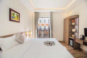 下龙湾Green bay hotel Ha Long的卧室配有一张白色大床和电视。