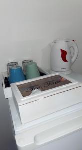 阿尔勒舒适旅馆的白色冰箱,有三个杯子和咖啡杯