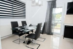 尼亚普拉莫斯Mistral Luxury Living的一间设有玻璃桌和黑色椅子的用餐室