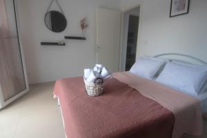 尼亚普拉莫斯Mistral Luxury Living的一间卧室配有一张带毛巾篮的床