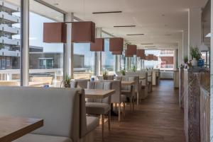 库克斯港克里斯廷森酒店的餐厅设有桌椅和大窗户。
