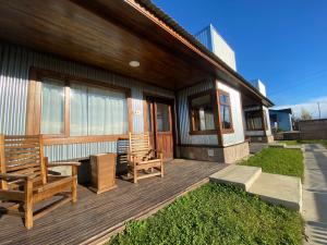 埃尔卡拉法特Patagonia Austral Suites的房屋内带2张长椅的木甲板