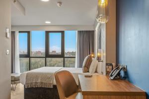 泰恩河畔纽卡斯尔纽卡斯尔市榕目兹酒店的酒店客房配有一张床、一张书桌和一部电话